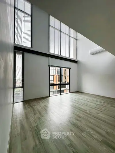 Spacious modern living room with high ceilings and large windows for natural light.