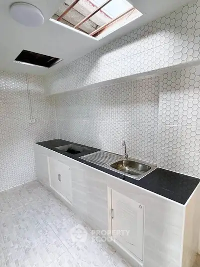 Modern kitchen with sleek countertops and hexagonal tile backsplash