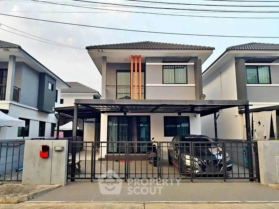 Modern two-story house with carport and gated driveway in suburban neighborhood.