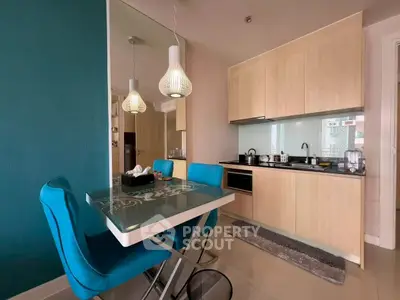 Modern kitchen with sleek cabinetry and stylish dining area in vibrant apartment.