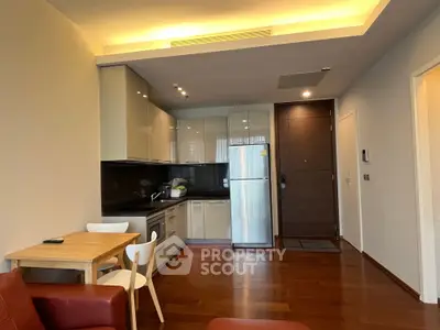 Modern kitchen with sleek cabinets and dining area in open layout apartment.