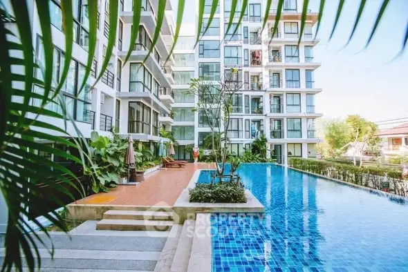 Luxurious apartment complex with a stunning outdoor pool and lush greenery.