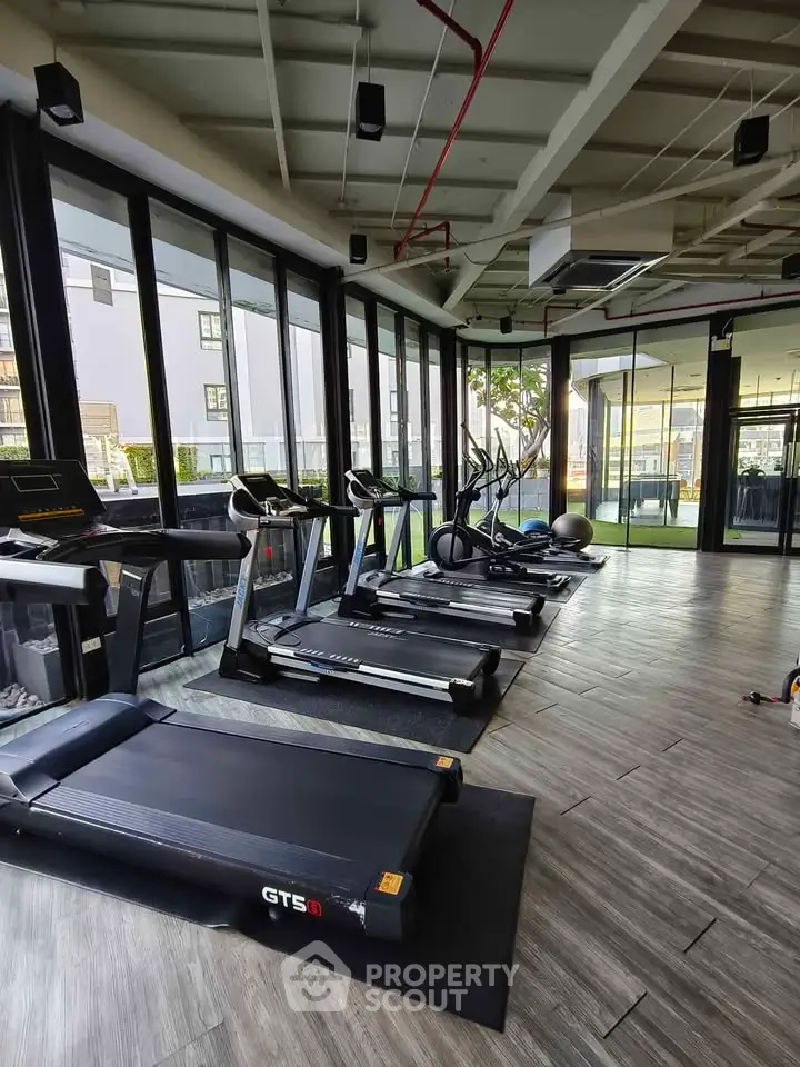 Modern gym with state-of-the-art equipment and large windows for natural light.