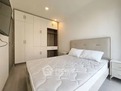 Modern bedroom with sleek wardrobe and comfortable bed in bright apartment.