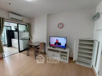 Modern living room with TV, dining table, and view into sleek kitchen