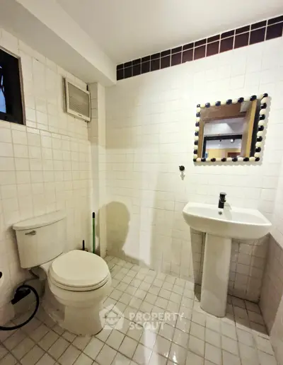 Modern bathroom with white tiles and sleek fixtures