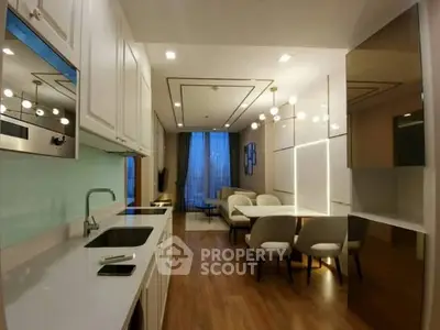 Modern open-layout kitchen and dining area with sleek design and elegant lighting.