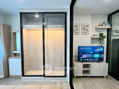 Modern living room with sleek TV setup and stylish glass wardrobe