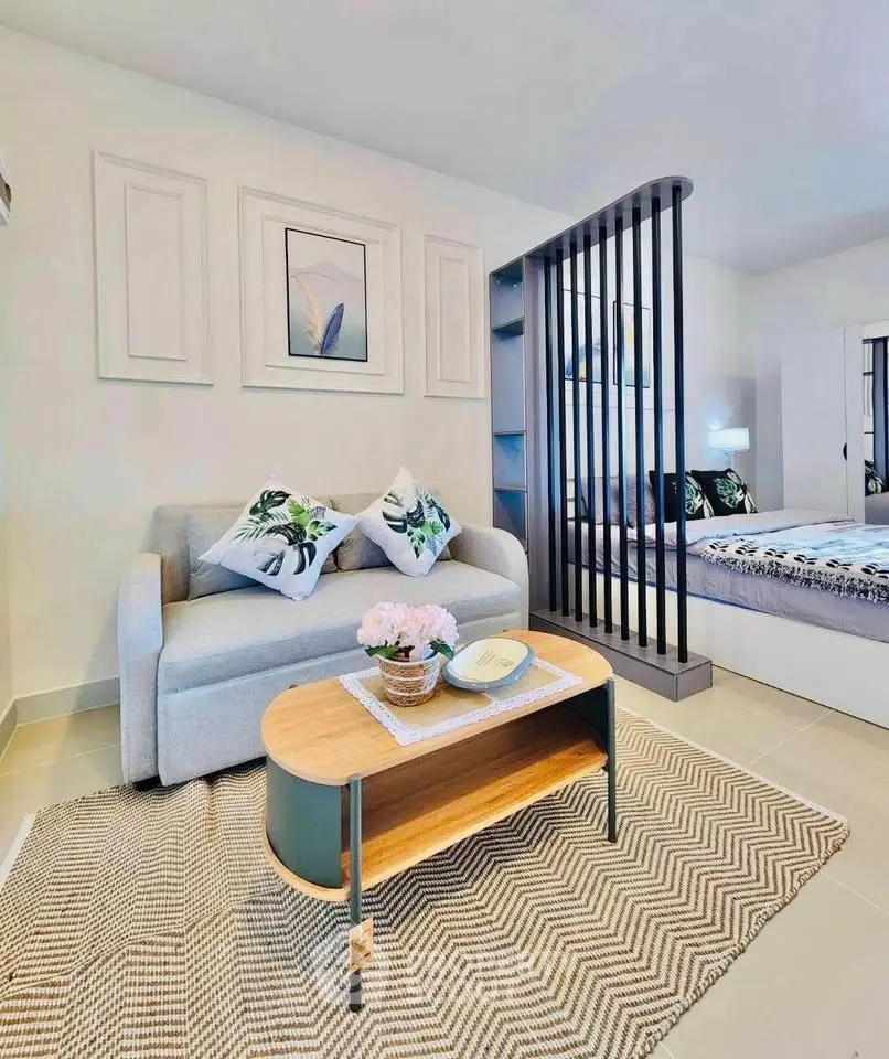 Stylish modern living room with cozy sofa and chic decor in open-plan apartment.