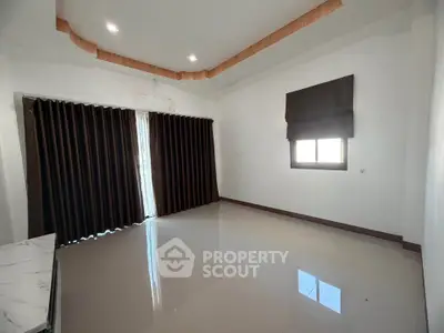 Spacious empty room with large windows and modern ceiling design