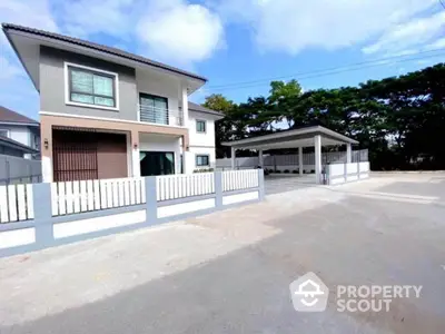 Modern two-story house with spacious driveway and carport in a serene neighborhood.