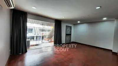 Spacious living room with hardwood floors and large windows for natural light.
