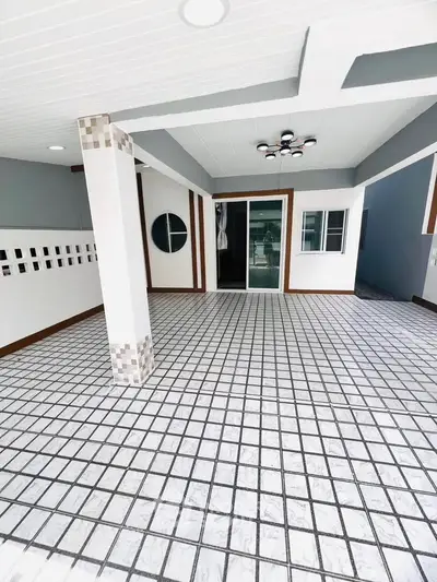 Spacious tiled entrance with modern lighting and sliding glass doors, perfect for welcoming guests.