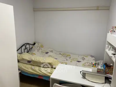 Cozy small bedroom with single bed and study desk, ideal for compact living.