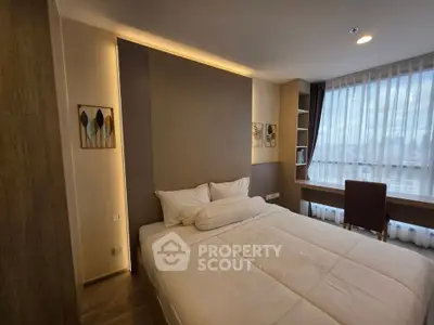 Modern bedroom with large window and stylish decor in a high-rise apartment.