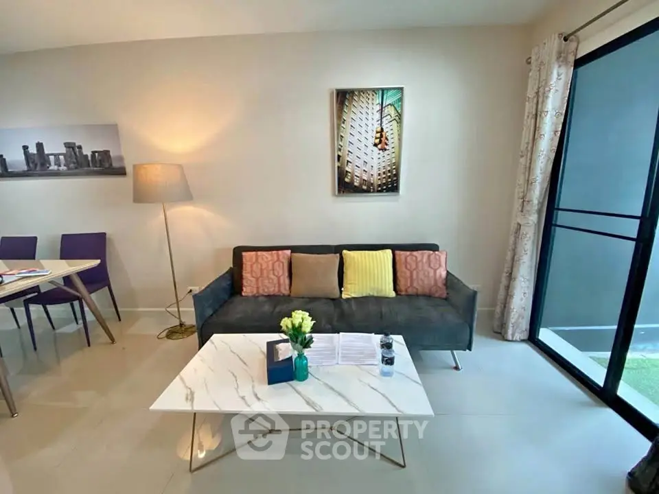 Modern living room with stylish decor and balcony access in a contemporary apartment.