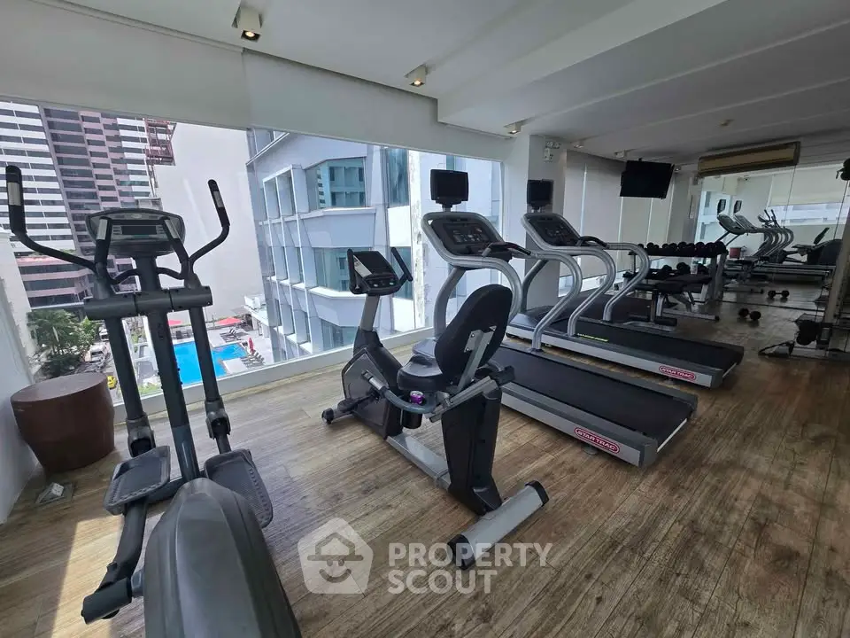 Modern gym with state-of-the-art equipment and city view, perfect for fitness enthusiasts.