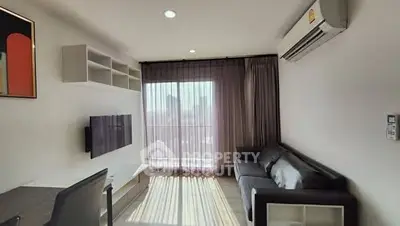 Modern living room with large window and city view, featuring sleek furniture and air conditioning.