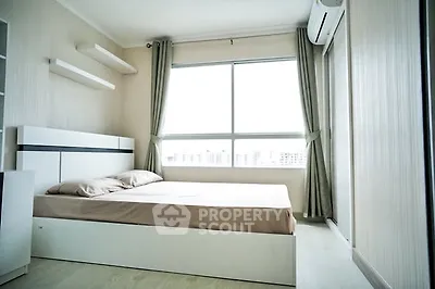 Modern bedroom with large window and minimalist design in a bright apartment.