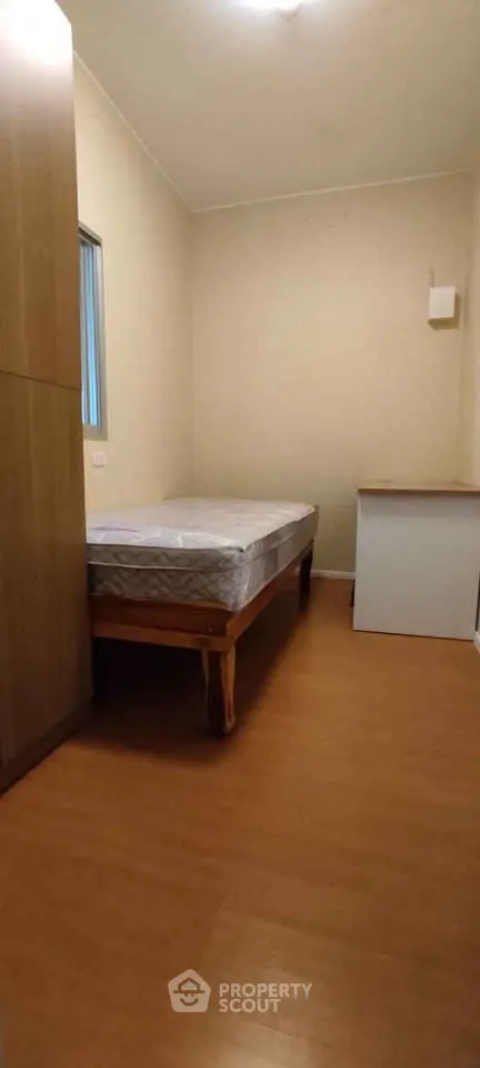 Cozy bedroom with wooden flooring and minimalist furniture