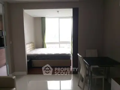 Modern studio apartment with cozy bedroom and dining area, featuring large window for natural light.