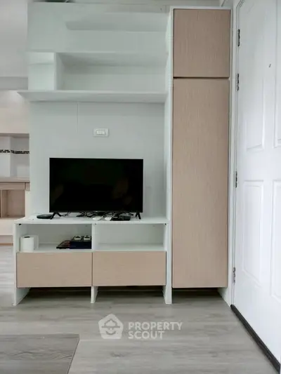 Modern living room with sleek TV unit and storage, showcasing minimalist design and functionality.