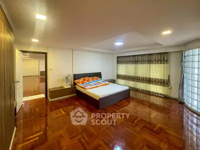 Spacious bedroom with wooden flooring and modern decor