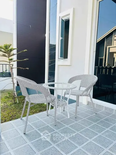 Charming outdoor patio with modern wicker furniture and garden view, perfect for relaxation.