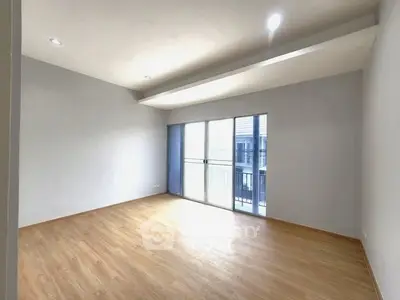 Spacious empty living room with large windows and wooden flooring