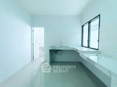 Spacious minimalist kitchen with sleek countertops and large windows