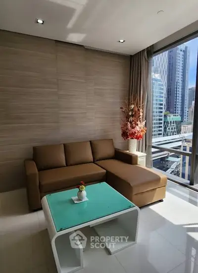 Modern living room with city view, featuring a stylish brown sofa and glass coffee table.