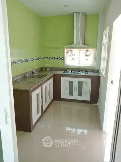 Modern kitchen with sleek design and gas stove in a compact layout.