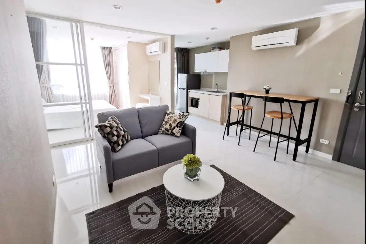 Modern open-plan living room with stylish furniture and kitchen area