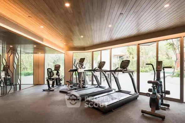 Modern gym with state-of-the-art equipment and large windows offering garden views.