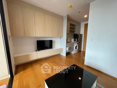 Modern living room with built-in cabinets and compact kitchen appliances