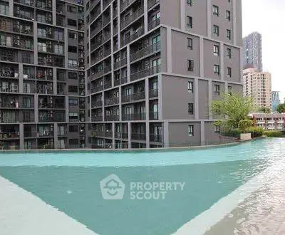 Modern residential building with infinity pool offering stunning city views.