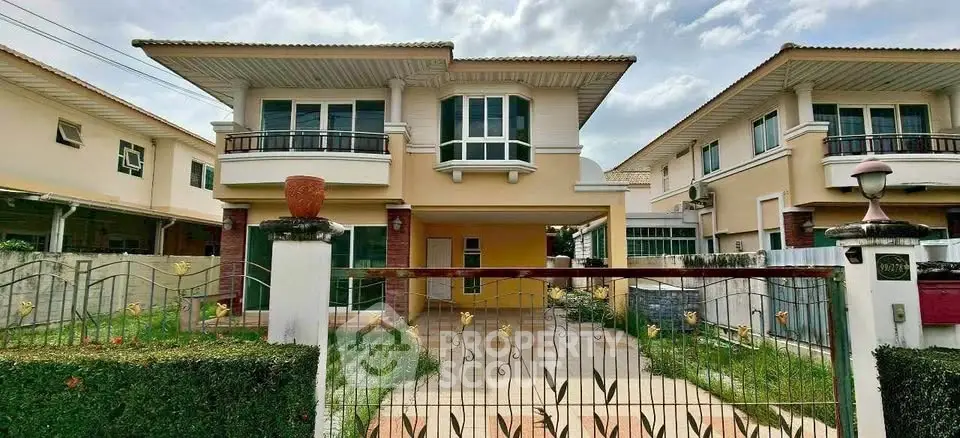 Charming two-story house with a spacious driveway and lush garden, perfect for family living.