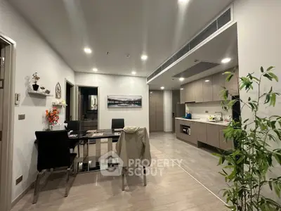 Modern open-layout kitchen and dining area with sleek design and ambient lighting.