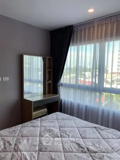 Cozy bedroom with large window and elegant curtains, featuring a stylish vanity desk.