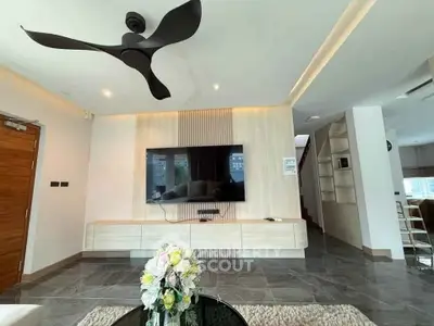 Modern living room with sleek design, large TV, and stylish ceiling fan.