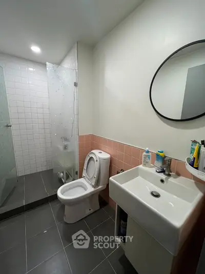 Modern bathroom with glass shower and sleek fixtures in contemporary home.