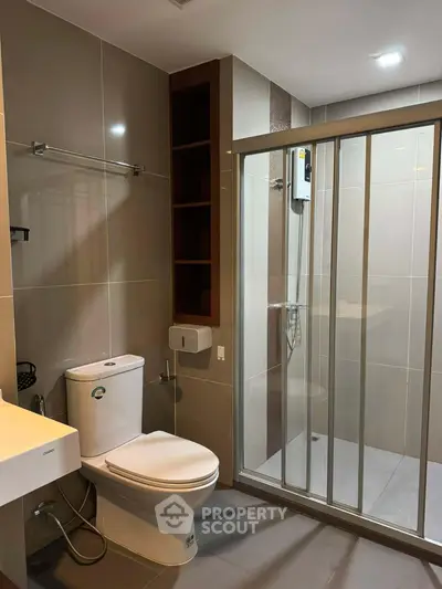 Modern bathroom with sleek design, featuring a glass-enclosed shower and contemporary fixtures.