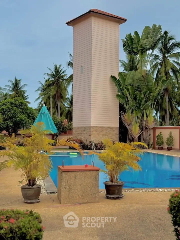 Luxurious tropical poolside with lush greenery and elegant architecture, perfect for relaxation and leisure.