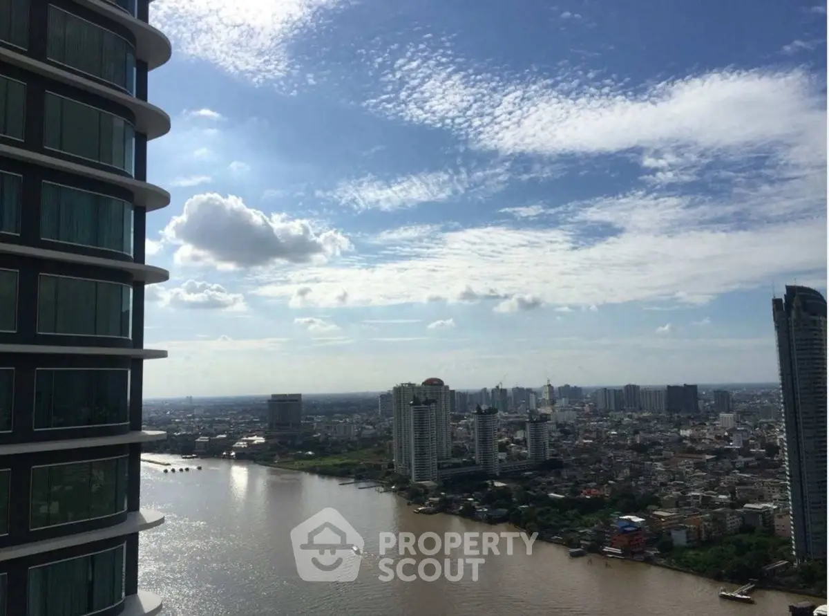 Stunning river view from high-rise building with cityscape and blue sky.