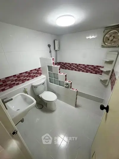 Unique bathroom with elevated shower area and modern tile design