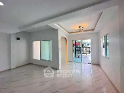 Spacious modern living room with large windows and elegant lighting, perfect for family gatherings.