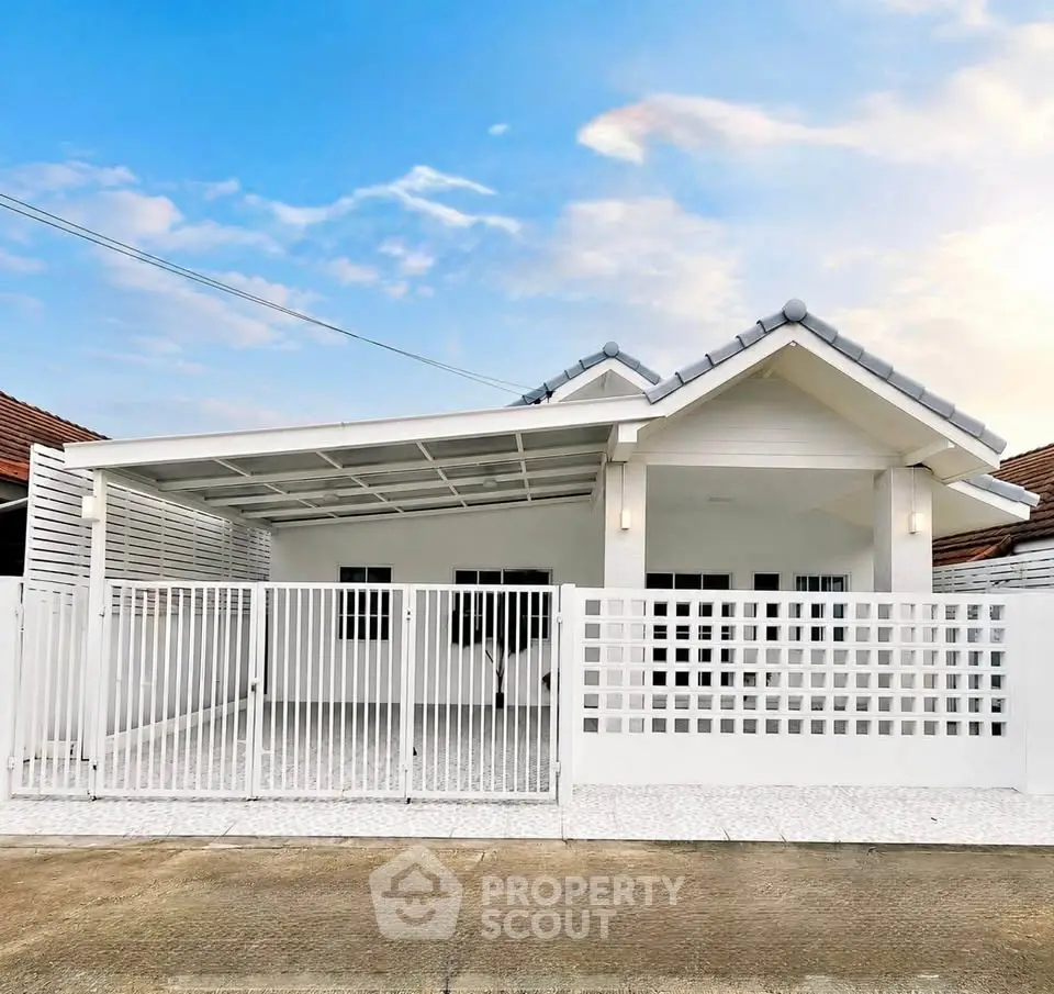 Charming white single-story house with modern fence and carport, perfect for cozy living.