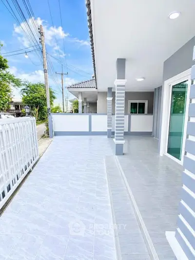 Modern house exterior with spacious tiled patio and sleek design