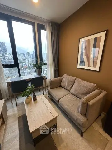 Modern living room with city view, cozy sofa, and stylish decor in high-rise apartment.
