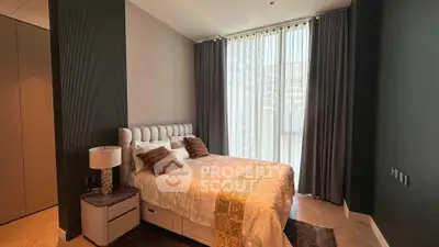 Luxurious bedroom with elegant decor and large window offering natural light